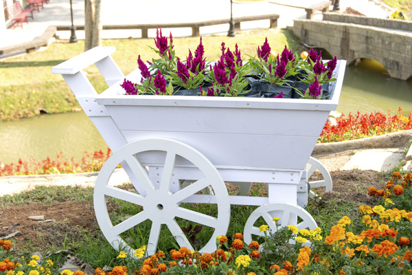 himsical container plantings, such as this flower cart, serve as the foundation for a traditional English cottage garden.